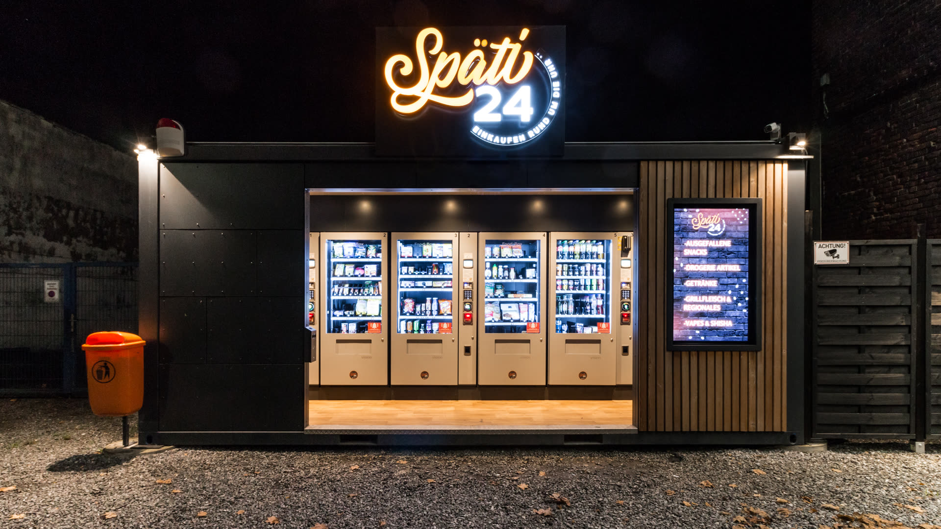 Späti24-Verkaufscontainer bei Nacht mit beleuchtetem Logo und Automaten